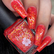 Red glittery nail polish with a visible brand name on a black background